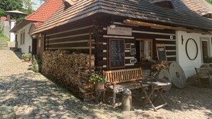 Un bâtiment rustique en bois, sur lequel on peut lire l’inscription : « HÔTEL ROMANTIK U RAKA ».