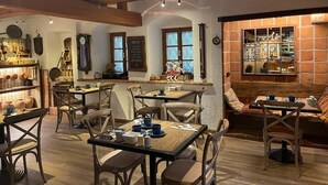 Un restaurant chaleureux, avec des meubles en bois, un mur en briques apparentes et une horloge au mur.