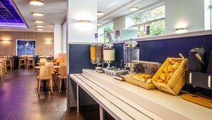 Una cafetería moderna con una barra alargada, zona de estar y un amplio ventanal.