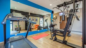 A gym with a treadmill, exercise bike, and weight machines. - Park & Suites Toulouse Colomiers (Toulouse)