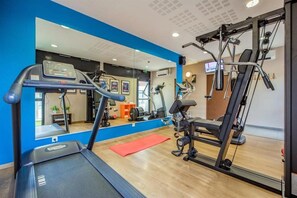 Et fitnesscenter med løbebånd, motionscykel og styrkemaskiner.