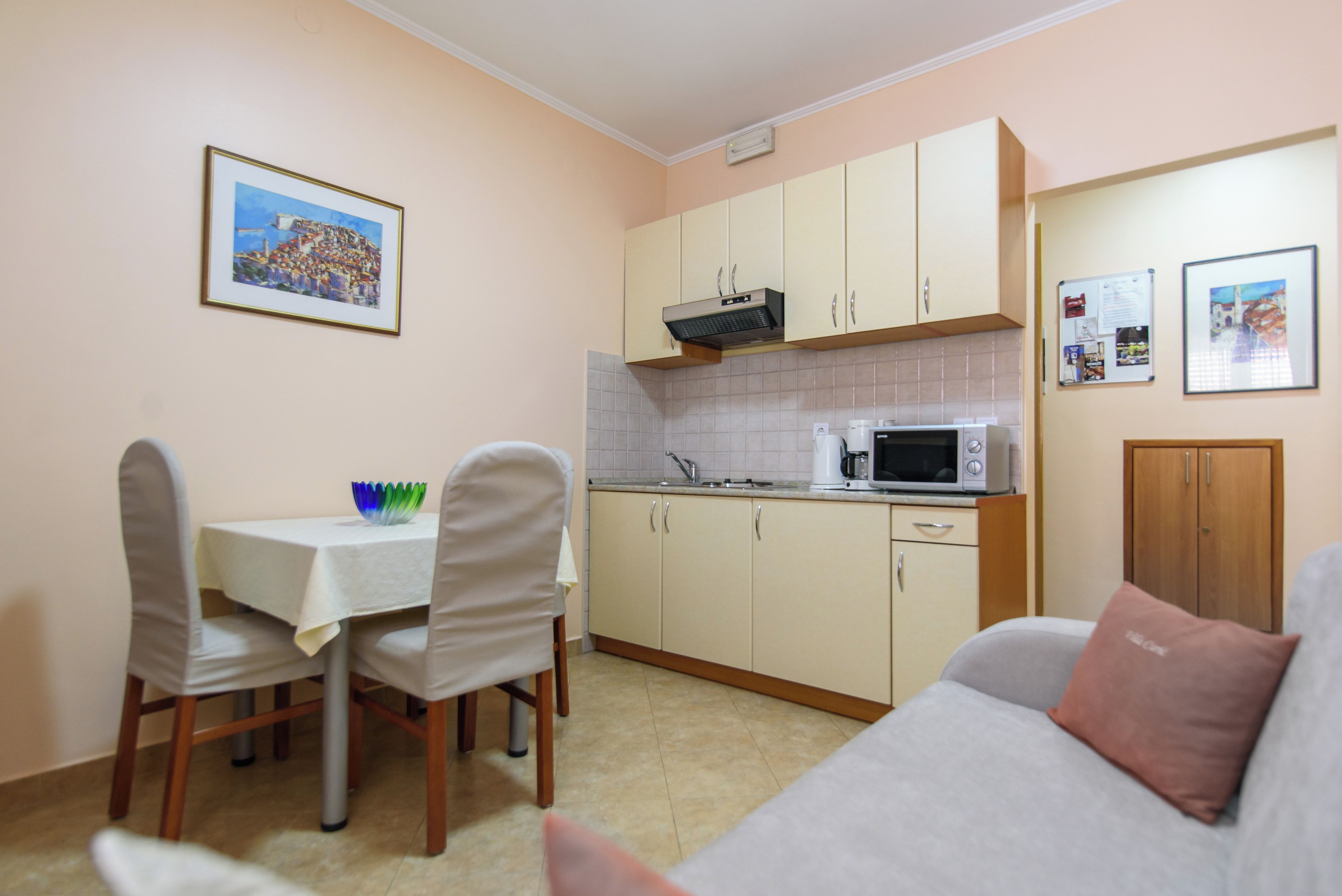 A compact kitchen with a dining area, a microwave, and a small table.