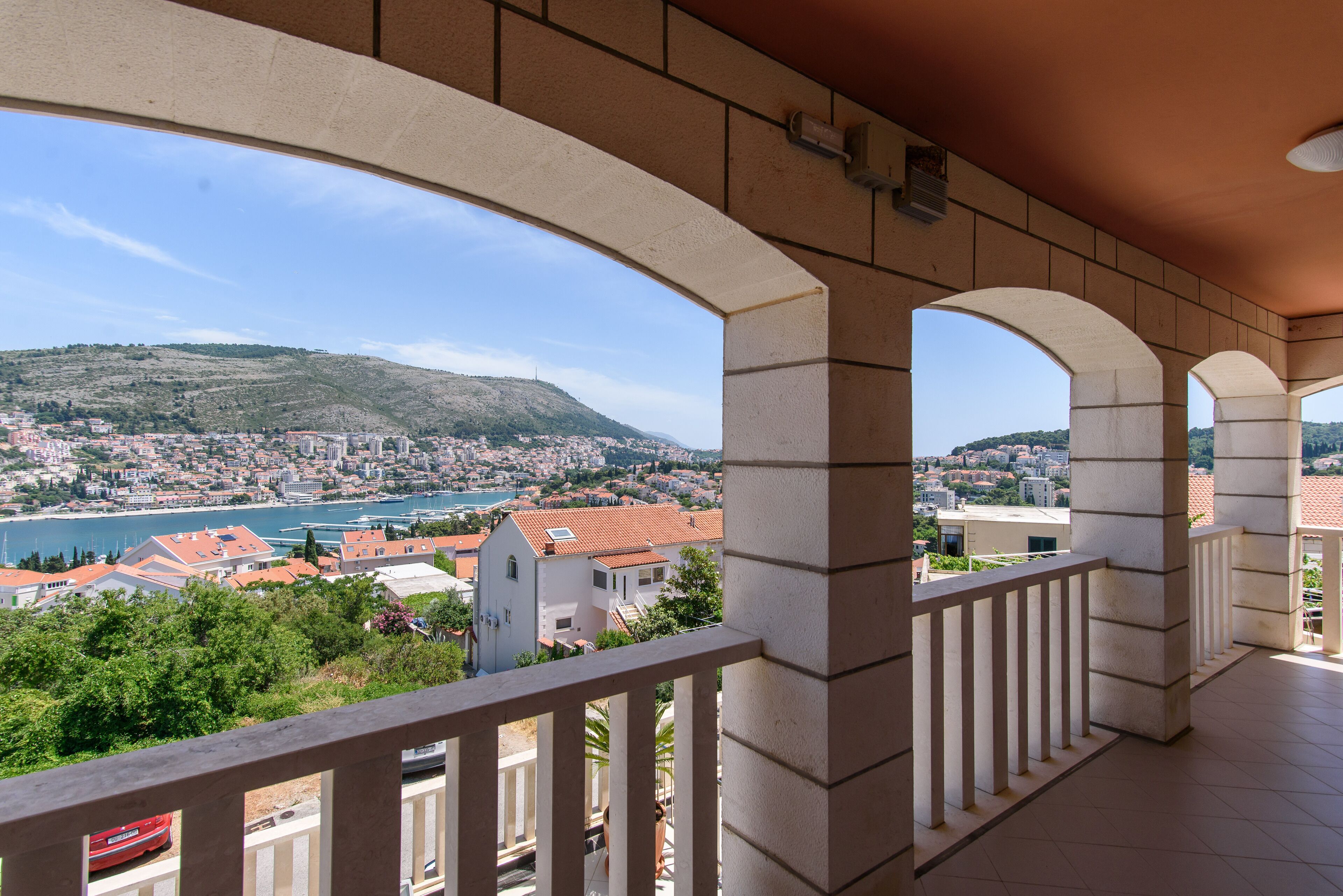 Varanda com vista para a paisagem costeira, incluindo uma colina e um corpo de água.