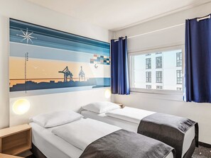 A hotel room with two beds, a wall art depicting a cityscape, a window with curtains, and a nightstand. - B&B Hotel Hamburg-Altona (Hamburg)