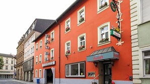 Un bâtiment rouge avec une enseigne indiquant «Hôtel Andries» et une entrée bien visible.
