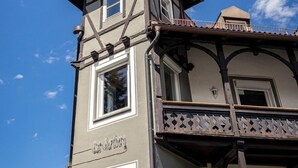 A two-story building with a balcony and a sign that reads "Löwengarten". - Das Nordberg Guesthouse (Garmisch-Partenkirchen)