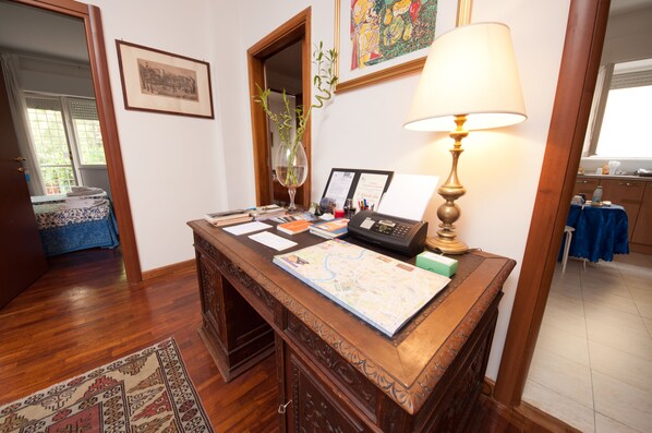 A wooden desk with a map, a lamp, and various papers.