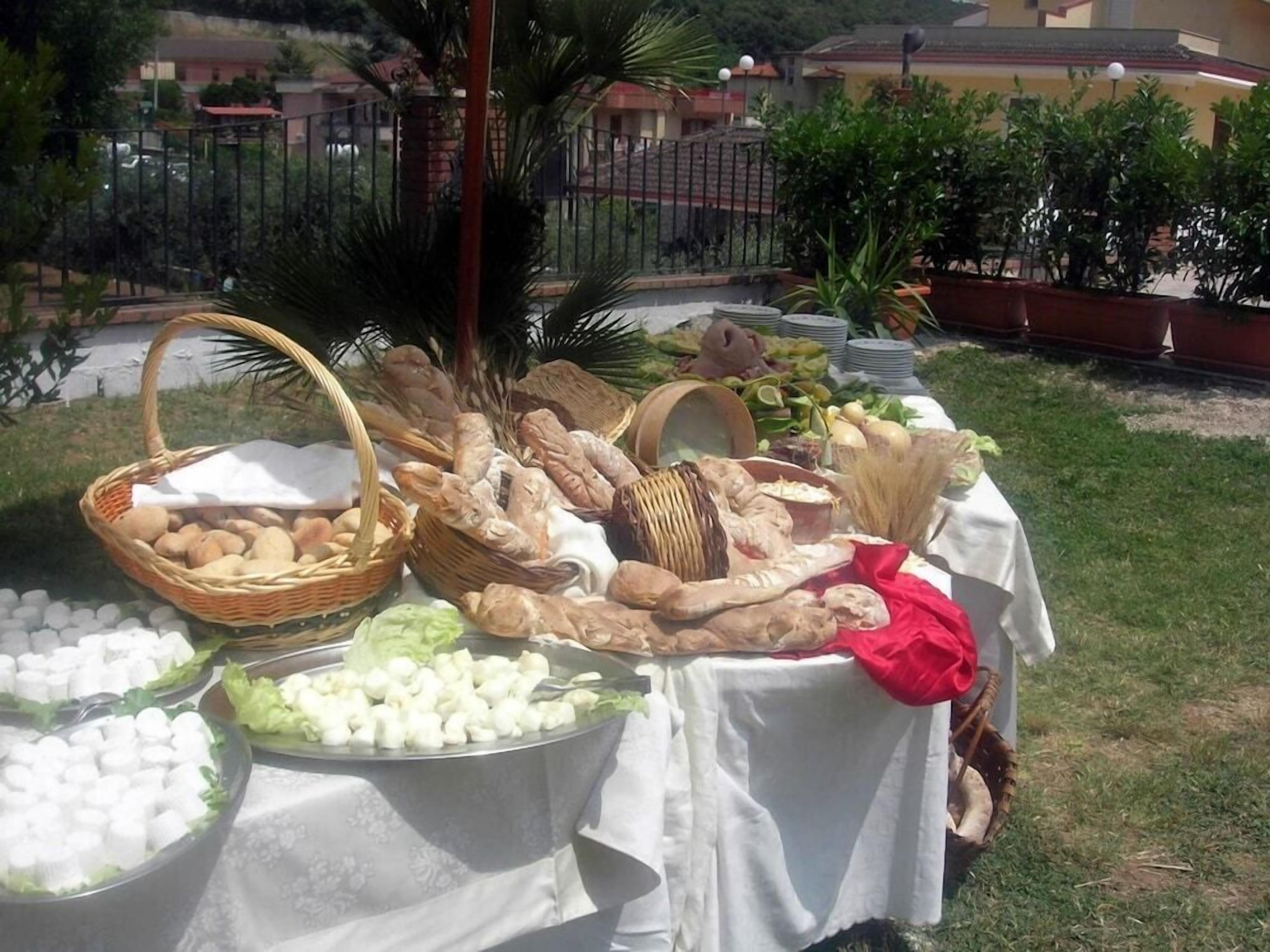 Un buffet all'aperto con diversi cibi e ceste su un tavolo.