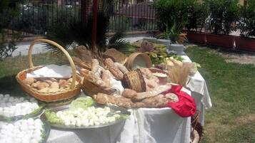Un buffet all'aperto con diversi cibi e ceste su un tavolo.