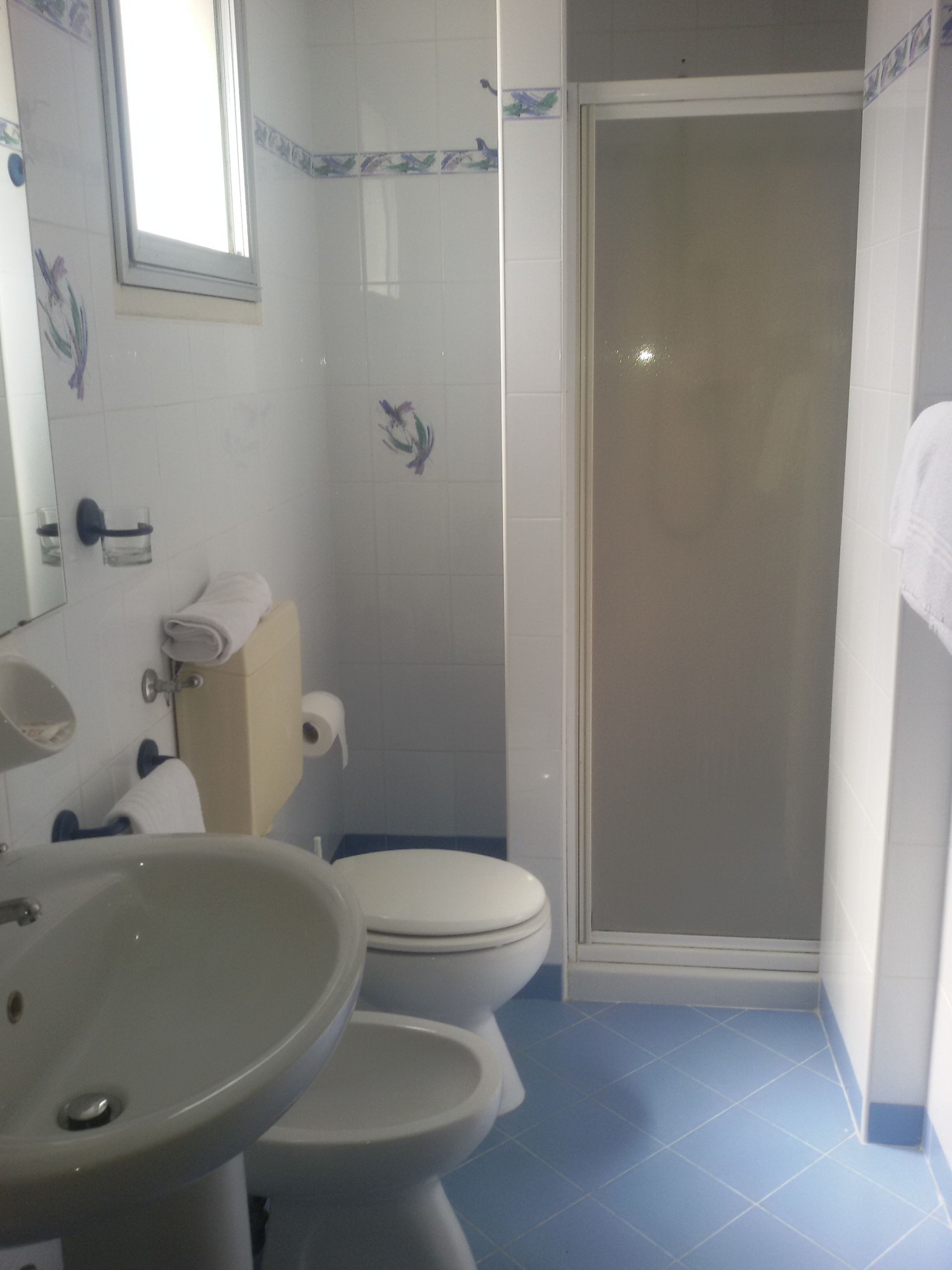 A bathroom with a sink, toilet, and shower.