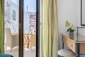 A room with a sliding glass door leading to an outdoor area with wicker furniture and a table.