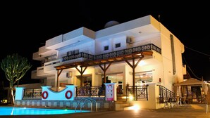 Un hôtel moderne doté d’une piscine, d’un espace extérieur aménagé et d’une terrasse couverte.