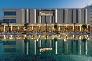 Um hotel com piscina, espreguiçadeiras e uma placa que diz 'Swandor'.
