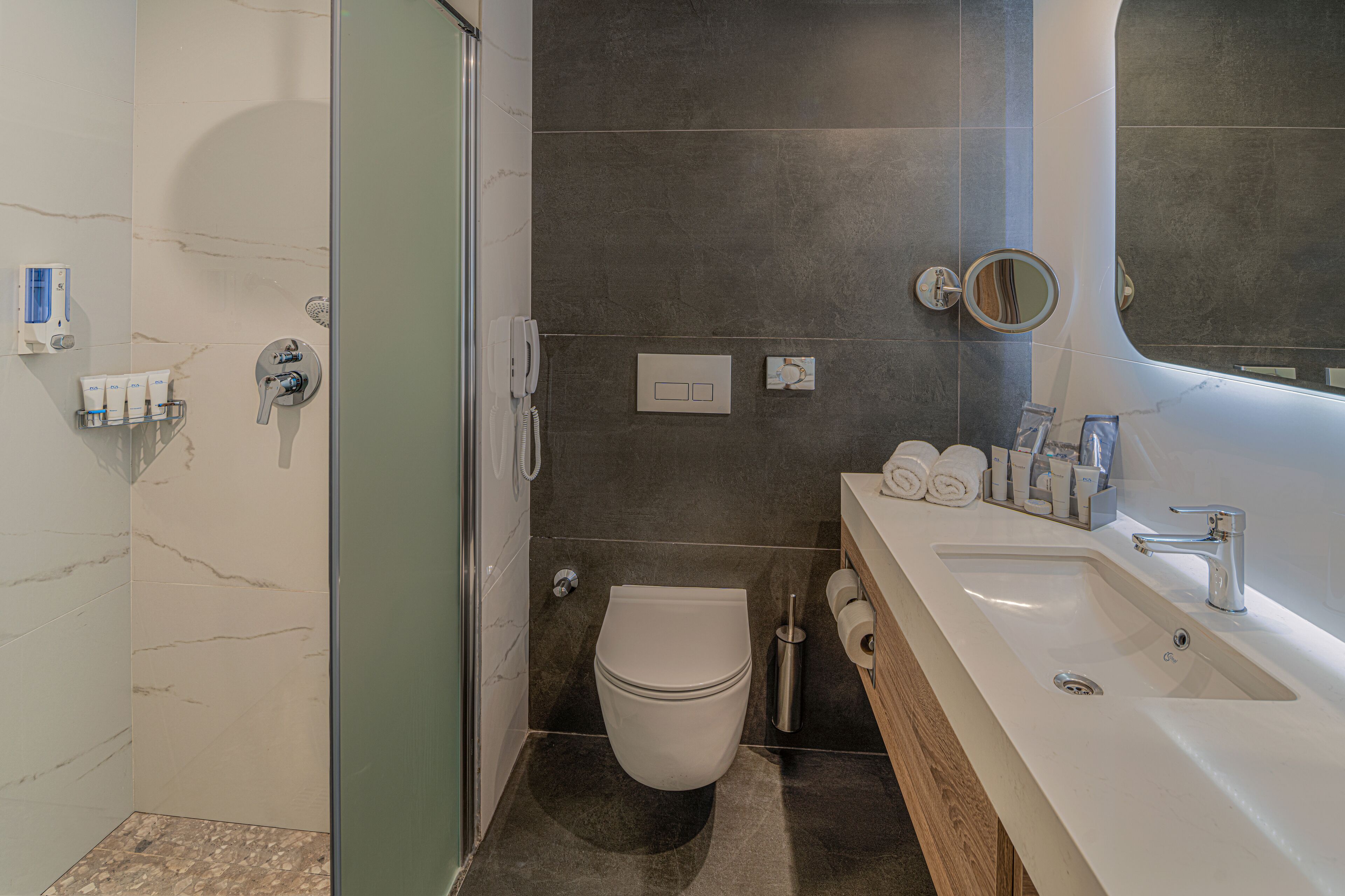 A modern bathroom with a toilet, sink, and shower.