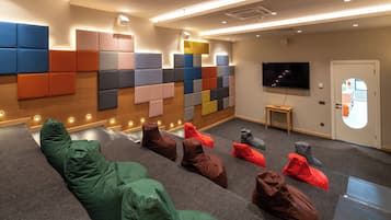 A modern lounge area with modular seating and a flat-screen TV.