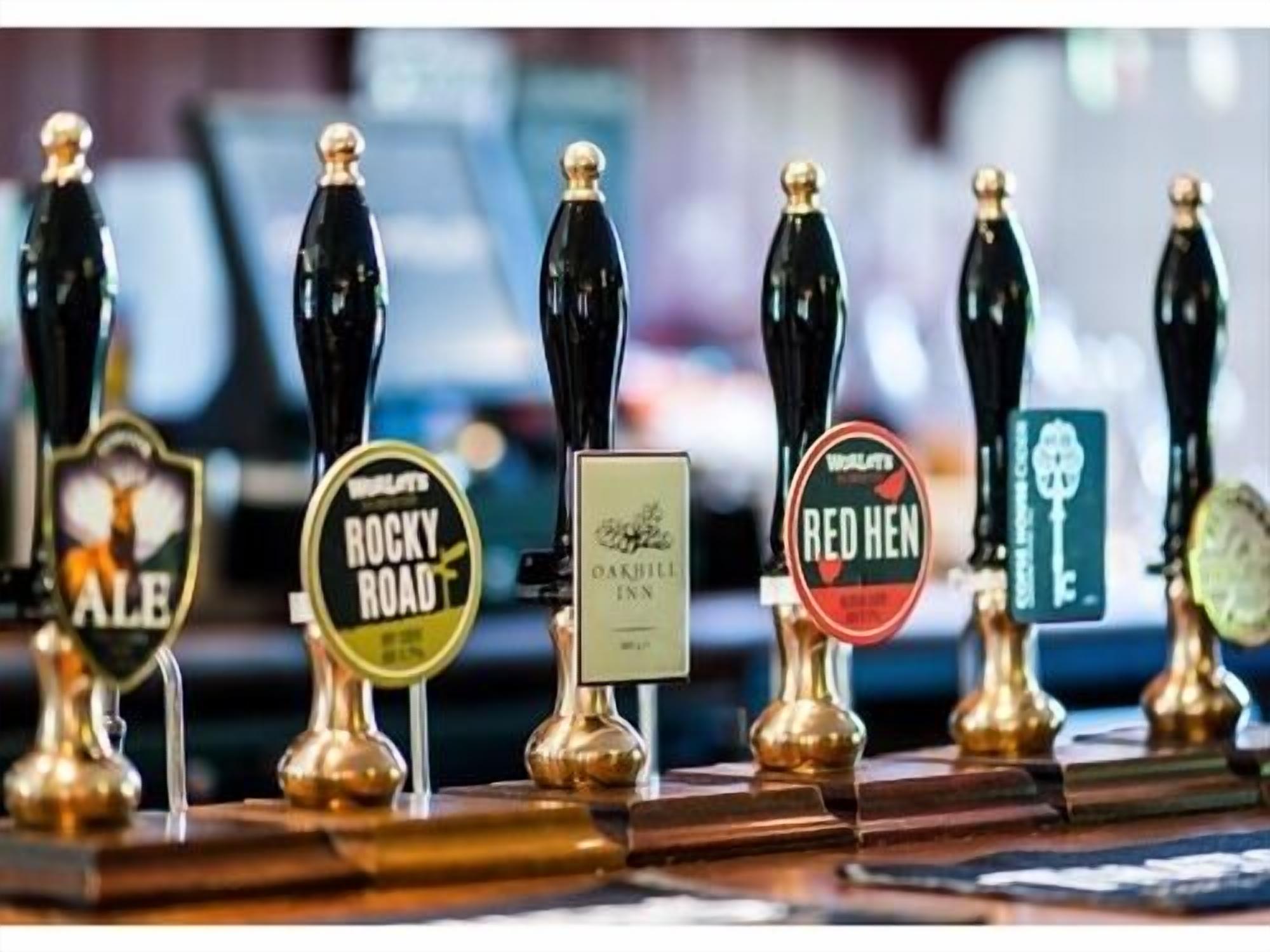 A row of beer taps with labels for different beers.