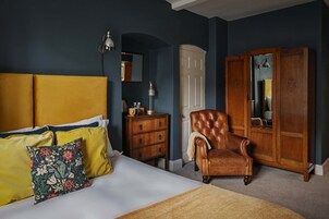 A bedroom with a bed, a dresser, a chair, and a wardrobe.