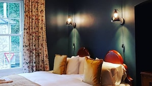 Ein Hotelzimmer mit Bett, Schreibtisch und einem Vorhangfenster.
