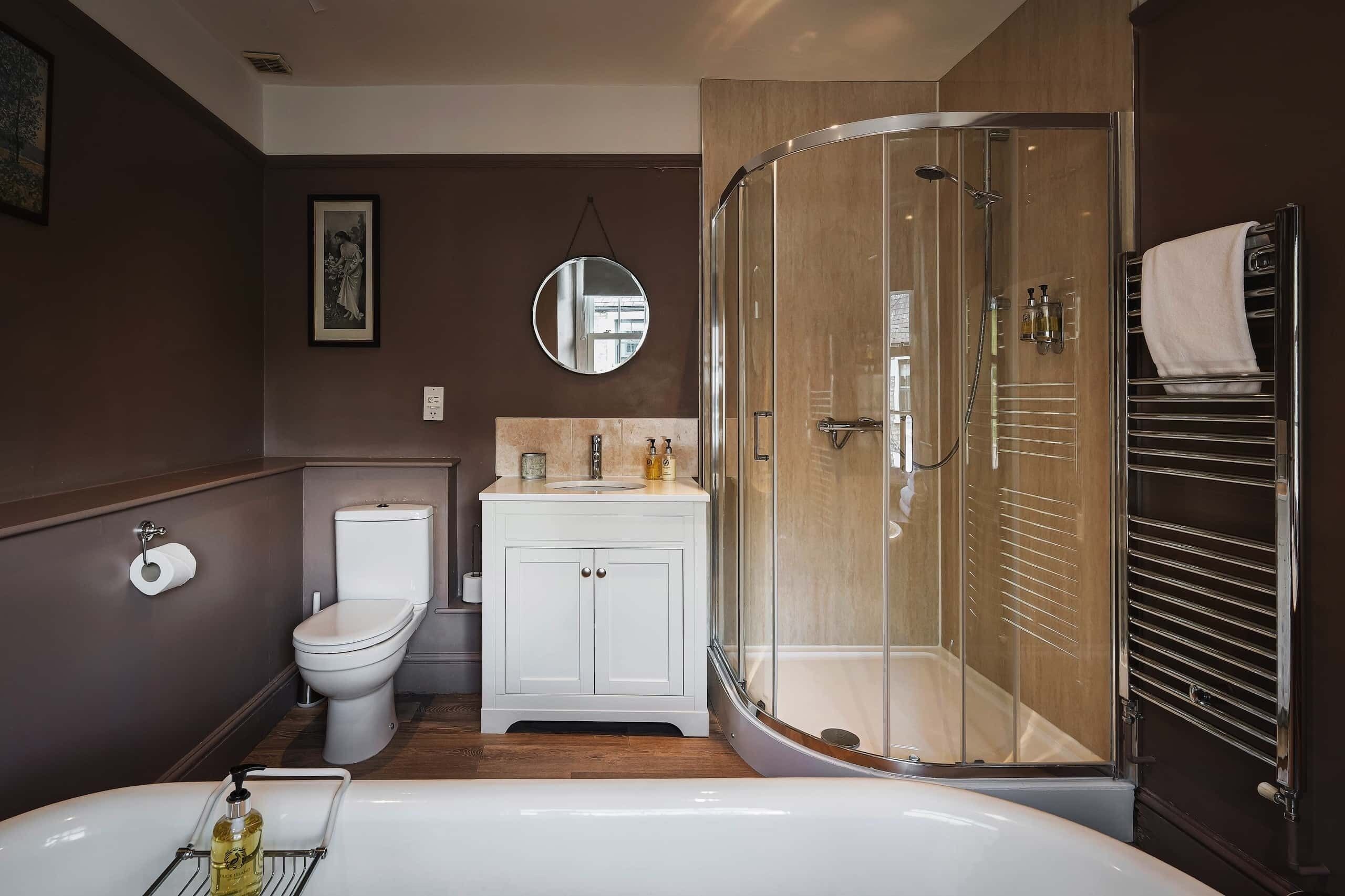 Un baño moderno con inodoro, lavamanos y ducha.