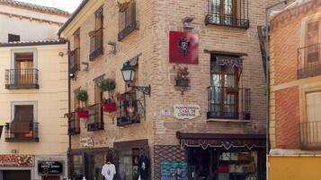 Un edificio histórico con un cartel que indica 'Hostal Casa de Cisneros' y una entrada visible.
