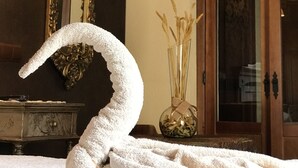 Een kamer met een grote spiegel, een houten deur en een vaas met gedroogde planten.