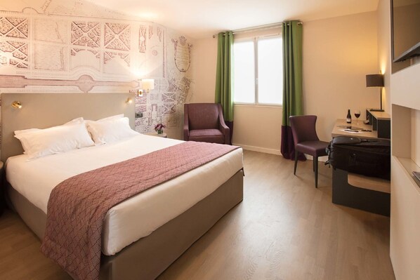 A hotel room with a large bed, two chairs, a desk with a computer, and a window with green curtains. - Hôtel Montbriand Antony (Antony)