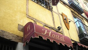 Rakennuksessa on kyltti, jossa lukee ”Hostal”, ja siinä on myös laatta, jossa on kaiverrettuna ”Alfonso XII”.