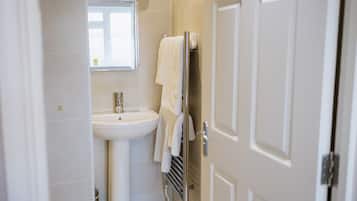 A bathroom with a white sink, a mirror, and a towel rack.