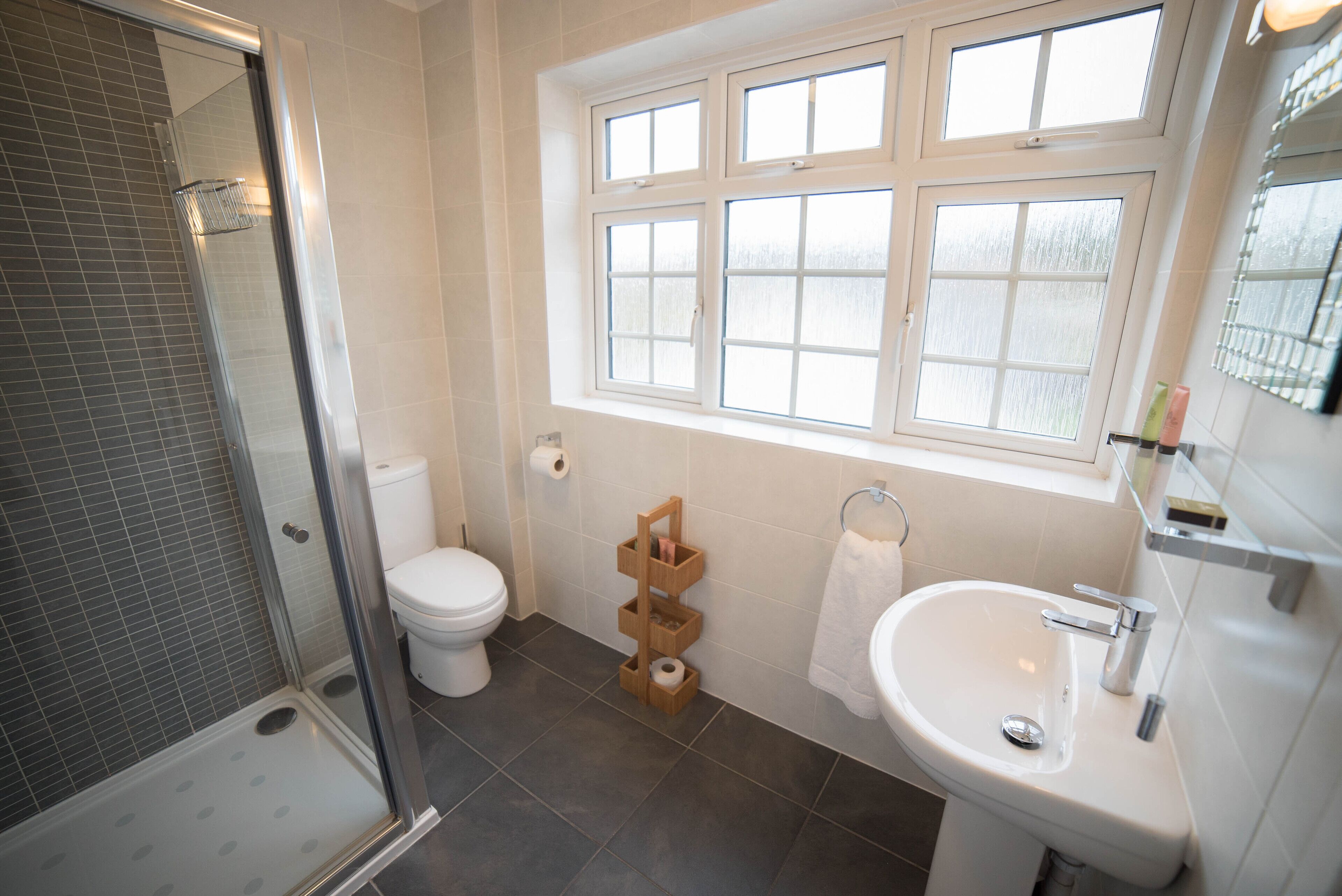 Un baño con ducha, inodoro, lavabo y ventana.