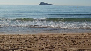 Una playa con arena y olas suaves.