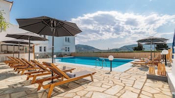 Piscine extérieure, parasols de plage, chaises longues