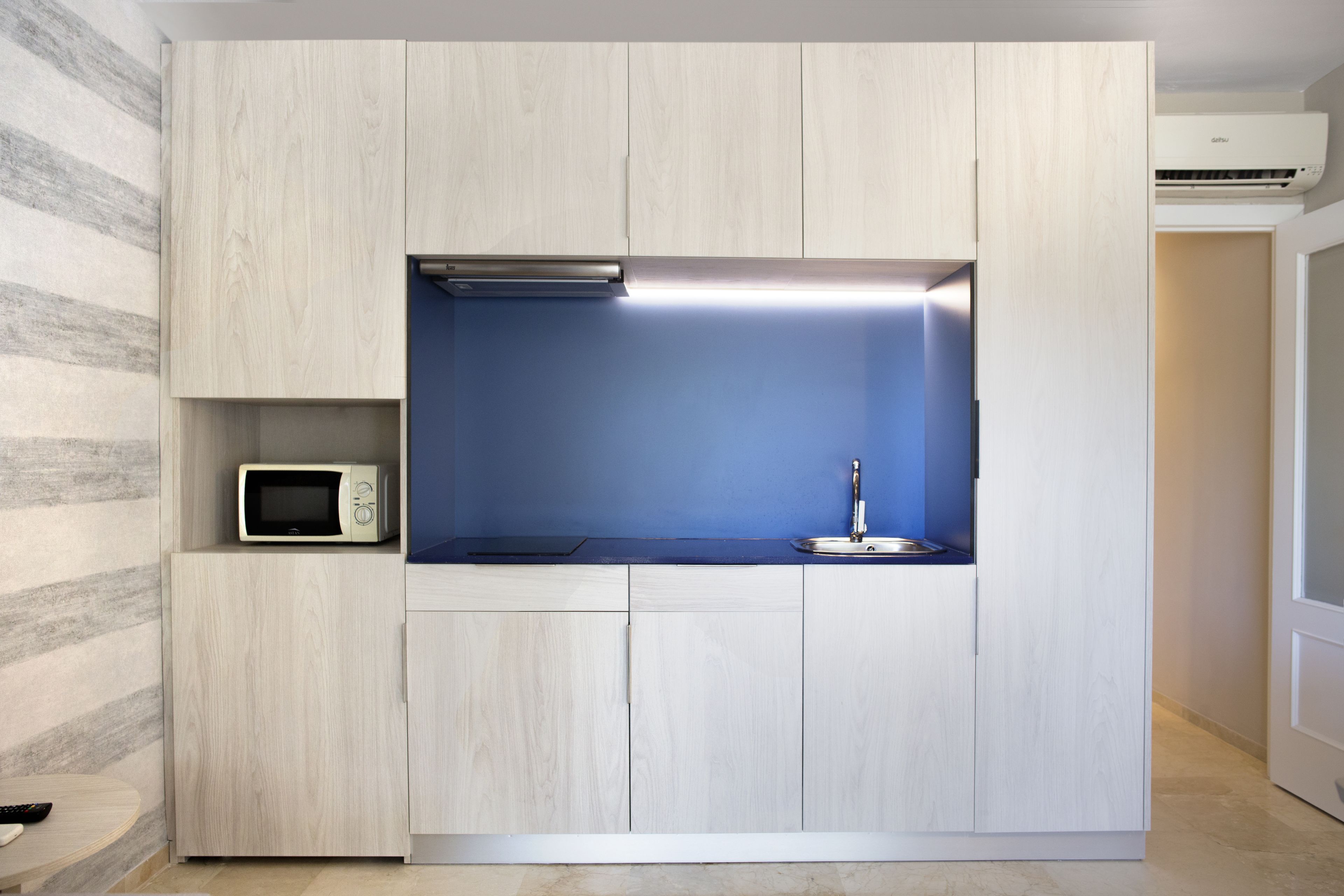 A compact kitchen with a microwave, a sink, and a built-in oven.