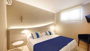 Una habitación de hotel con una cama, una mesita de noche y una silla.