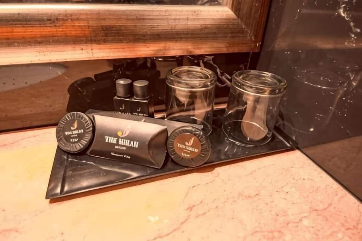 A kitchen with a black countertop, a coffee machine, and two glass containers.