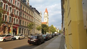 A street lined with historic buildings, a church with a tall spire, and parked cars. - Phoenix (Chemnitz)
