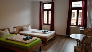 Quarto com duas camas, uma mesa e uma cadeira.