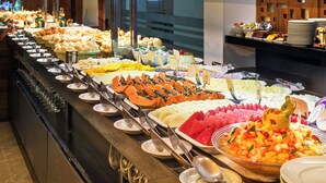 A buffet with various food items and utensils.