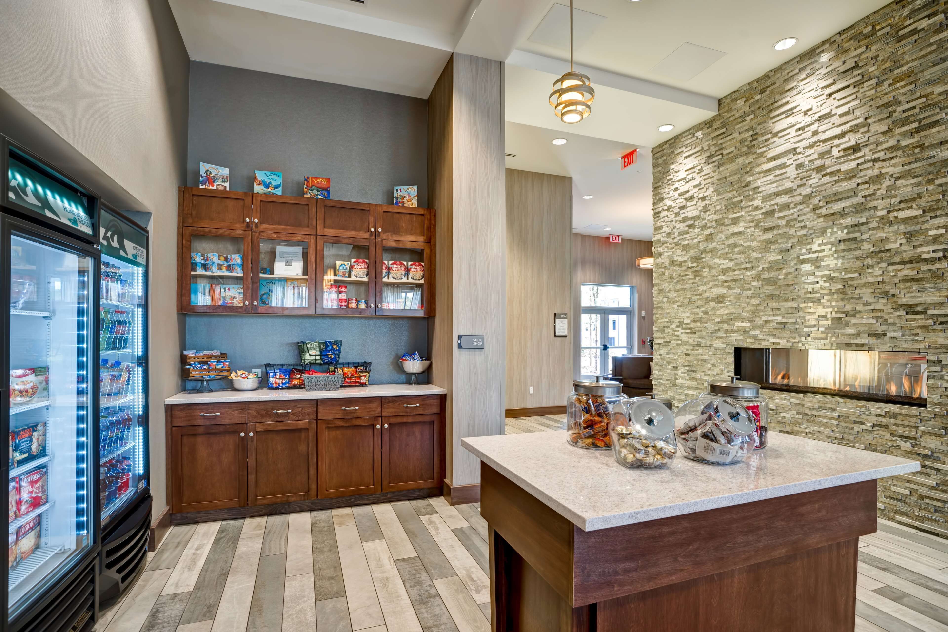 A modern kitchen with a stone accent wall, wooden cabinets, and a central island.