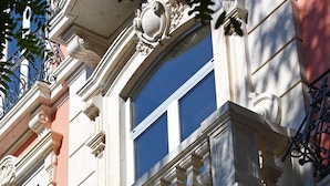 A building facade with ornate architectural details, including decorative moldings and a balcony with wrought iron railings. - Hotel Vincci Liberdade (Lisbon)