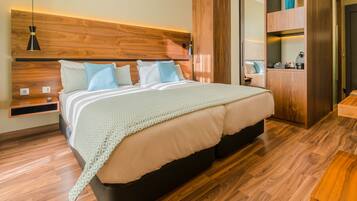A modern bedroom with a wooden headboard, a bed with patterned bedding, a bedside table, and a built-in wardrobe.