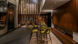 A modern interior with a bar area, seating, and a fireplace. - Hotel Vincci Liberdade (Lisbon)