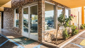 Un edificio con fachada de ladrillo, ventanas de vidrio grandes y una puerta con felpudo.