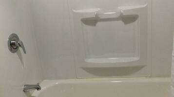 A white bathtub with a showerhead and a towel rack.