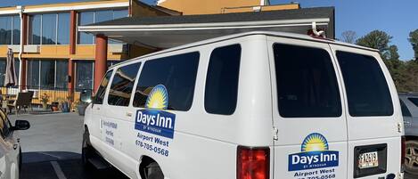 Una camioneta blanca con la marca Days Inn estacionada en un estacionamiento.