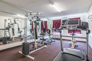 Work out in style with a fully equipped gym featuring a cable machine, bench press, and treadmill.