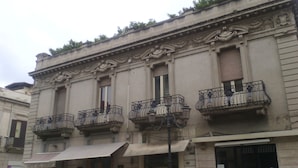 A building with ornate balconies and a sign reading "Caffè Del Corso". - Al Torrione (Reggio Calabria)