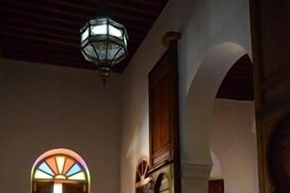 A hallway with a patterned floor, a wooden door, and a stained glass window.