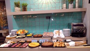 Un bufé con diversos alimentos y una máquina de café.