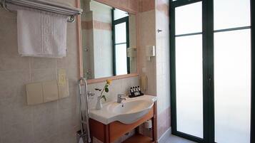 Un baño moderno con inodoro, lavamanos y espejo.