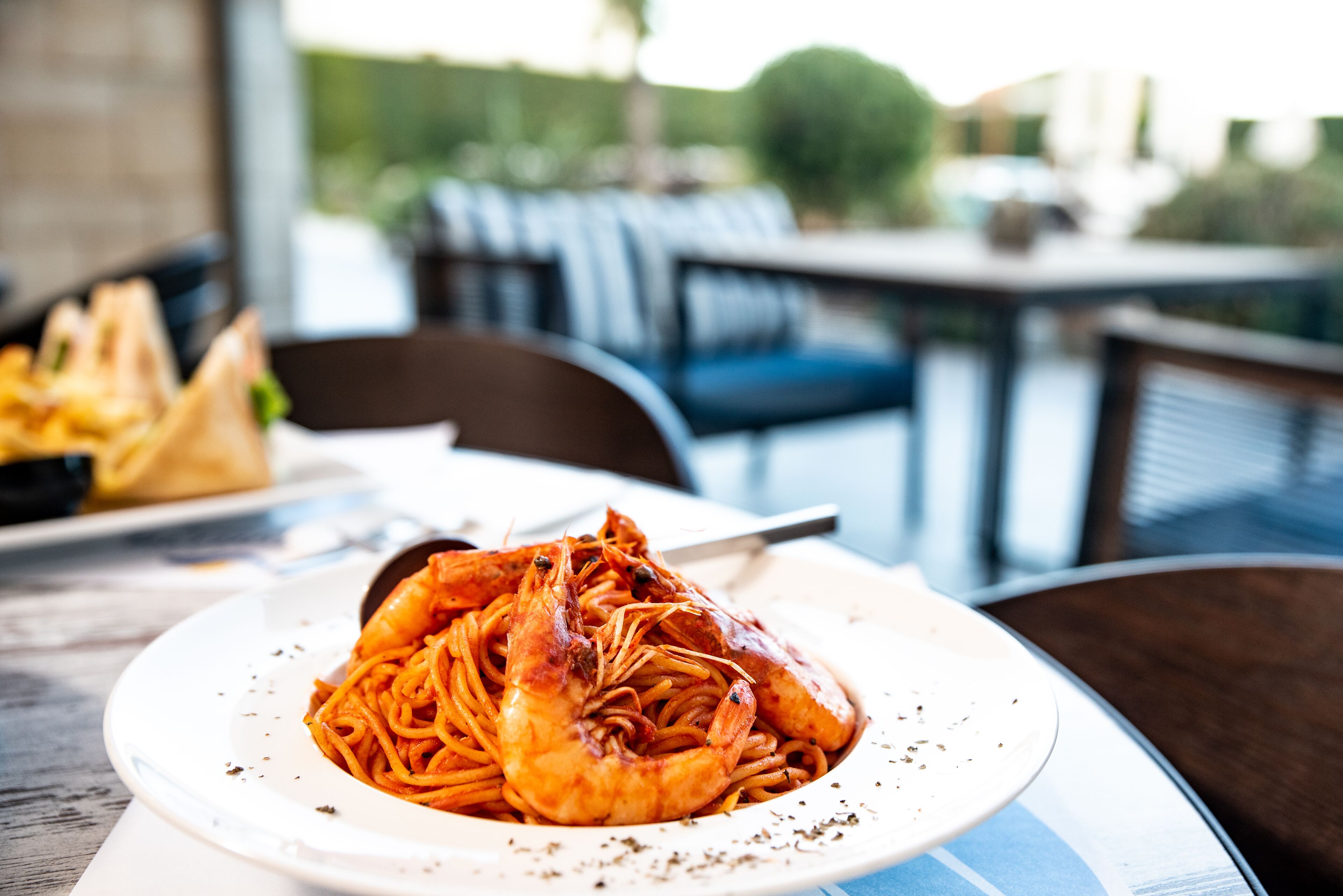 A plate of spaghetti with shrimp on a white plate.